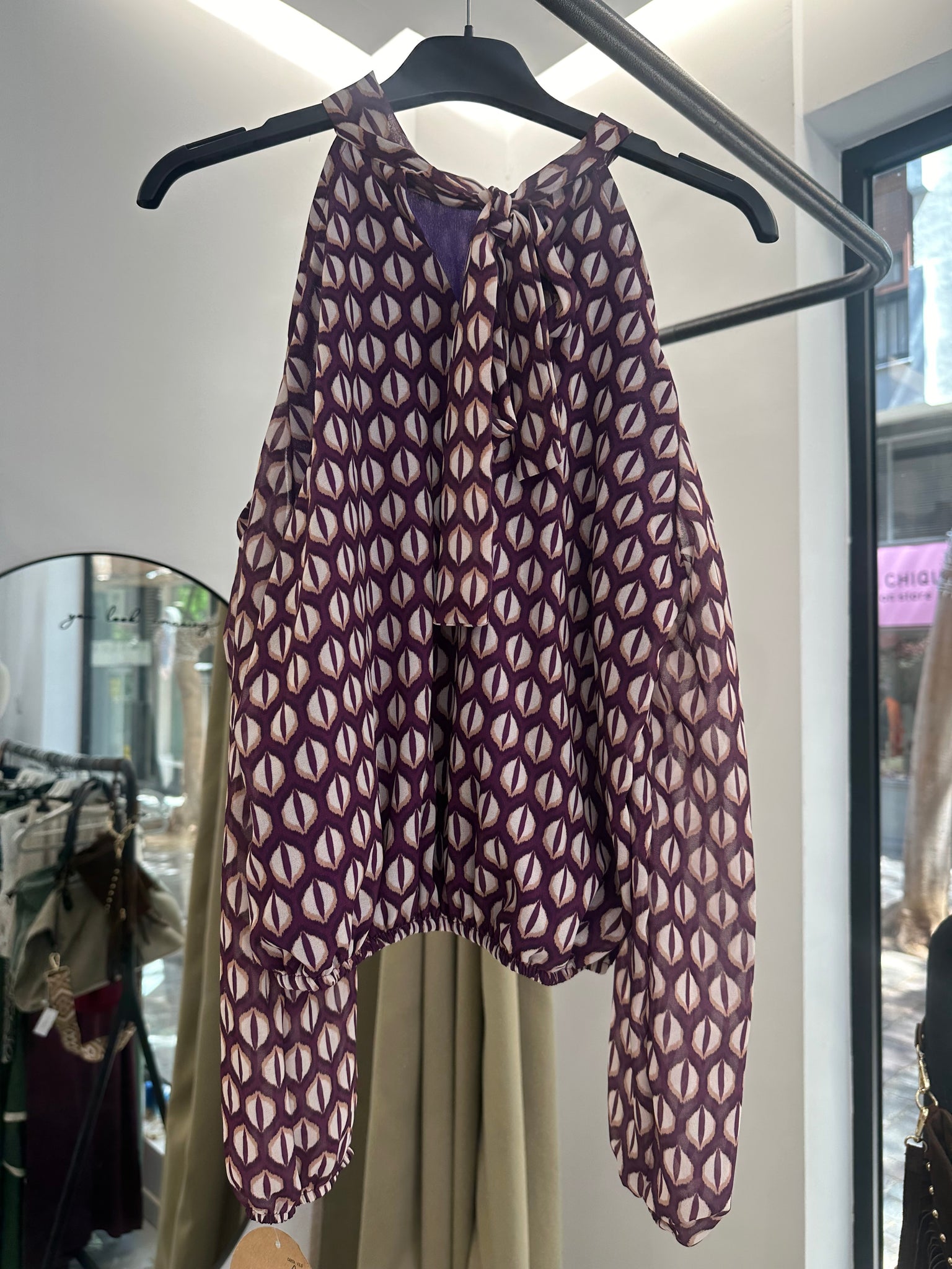 Top estampado geométrico con hombros descubiertos y cuello alto