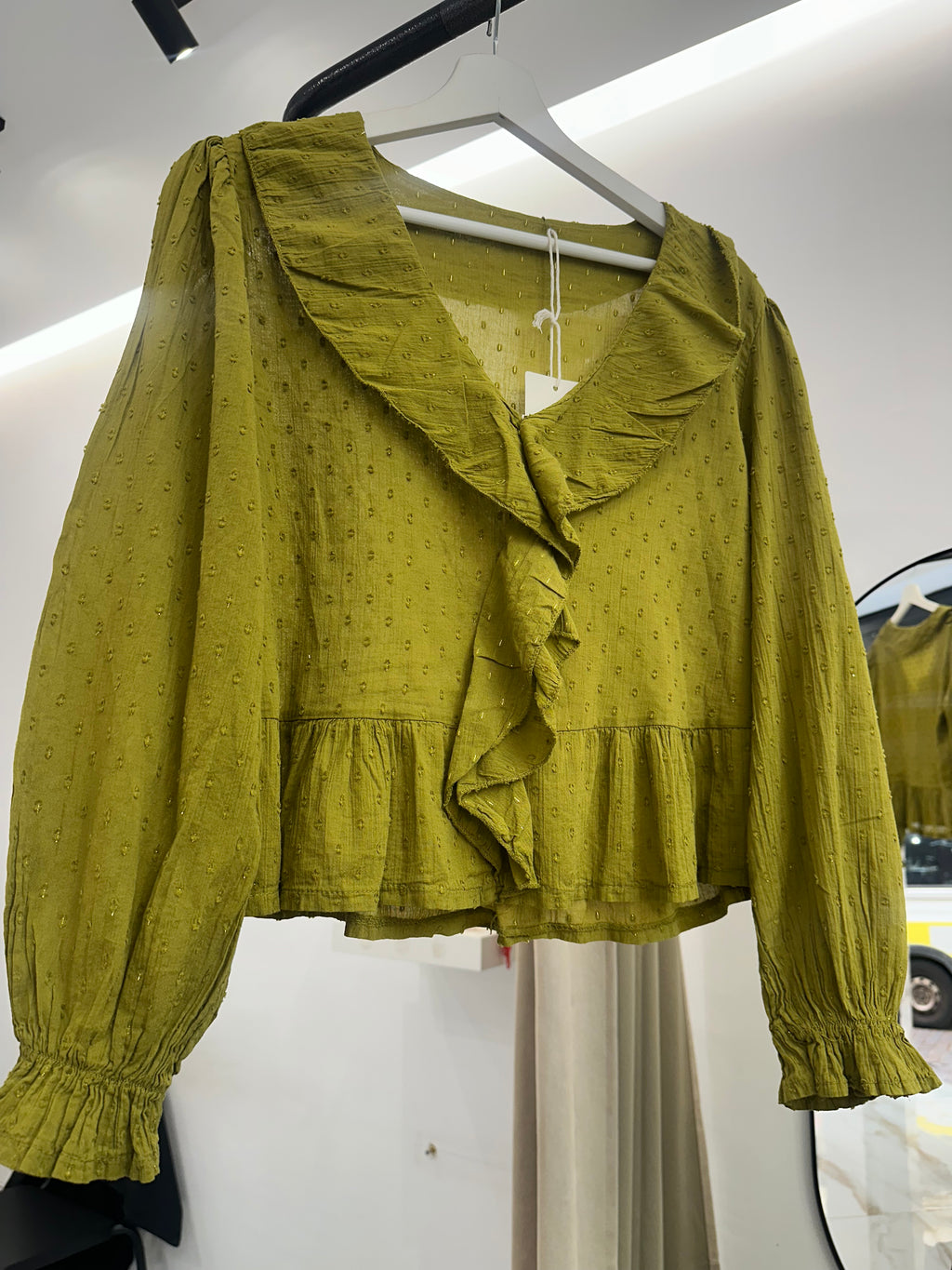 Blusa verde con volante delantero y detalles bordados